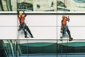 Window washers suspended on the side of a building