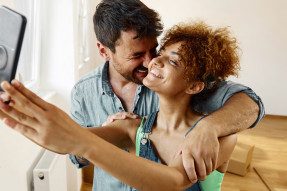 A couple in their home, taking a selfie