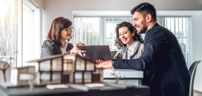 Side view image of young happy family sitting in consulting office, making property purchase.