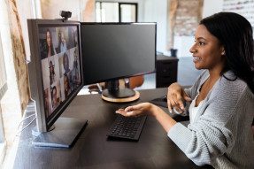 Businesswoman talks with colleagues during virtual meeting 