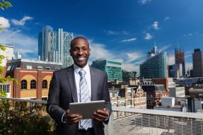 Outdoor portrait of African American businessman with digital tablet