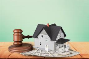 Mini house on top of cash with gavel