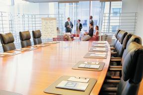 Board room table with members talking at end