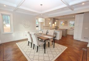 A dining room after renovation, stated with tables chairs and rug.
