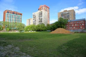 sand mound on field near apartment buildings 