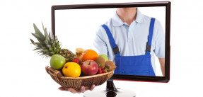 Farmer is holding fruit basket in computer
