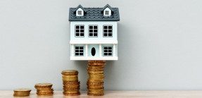 House Model on Top of Stack of Coins