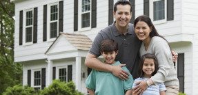 Hispanic family posing in front of house