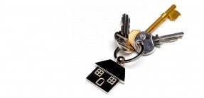 A picture of a set of keys on a ring with a simple house keychain