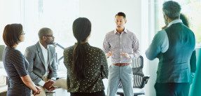 Businessman leading discussion during meeting in office