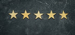 Five stars in a row on a black rustic cement board