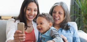 grandmother, daughter, grandson looking at phone