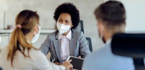 agent meeting with coworker or clients, all wear masks