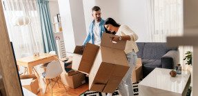 Couple unpacking boxes in apartment