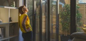 Woman enjoying sunlight through her home's windows
