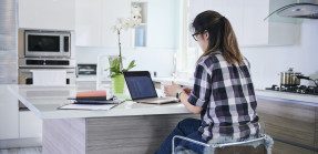 Woman working from home in kitchen 