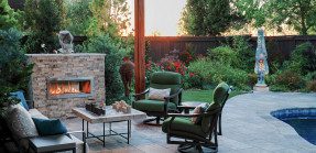 Backyard with outdoor fireplace, seating area, pool, garden, and outdoor sculpture