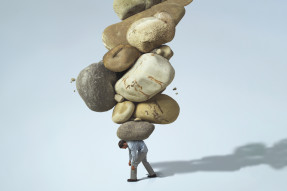 Burden, man carrying large rocks on his back