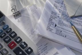 Calculator, receipts, tax forms, and a pen