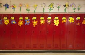 Red lockers in a school hallway, decorated with paper flowers