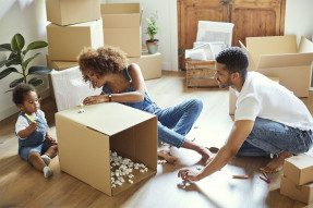 Family packing boxes on living room floor