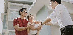Asian American couple receiving house keys from real esate agent