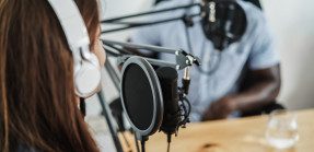 woman and man recording a podcast with microphones