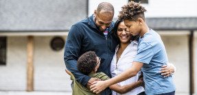 Black family in front of residential home