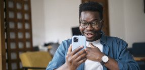 Young man looking relieved at phone