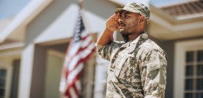 soldier saluting while standing outside his home