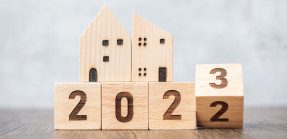 Flipping from 2022 to 2023 with house models on wooden blocks
