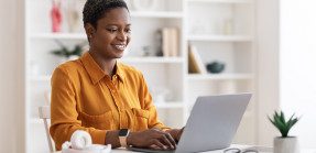 Woman sitting at computer and smiling
