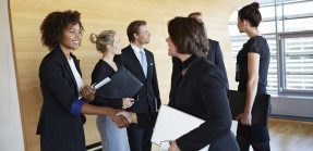 Business people greet each other at a networking event