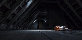 Baby doll laying on floor in dark attic