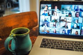 Green mug and Zoom meeting on a laptop