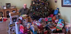 Jerry Moscowitz with toys around Christmas tree
