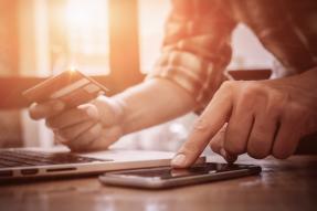 Man making an online purchase and calculating sales tax.