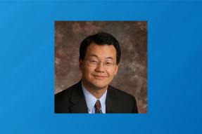 Headshot of NAR Chief Economist Lawrence Yun on a striped blue background