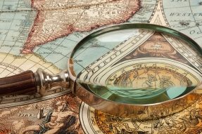 Magnifying glass on old world map