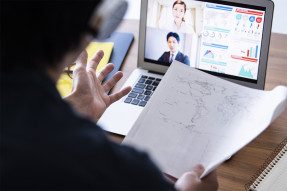Man holding world map and conducting virtual meeting