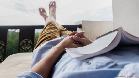 Man relaxing with book and feet up