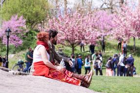 A woman and a man sitting on the ground in a park