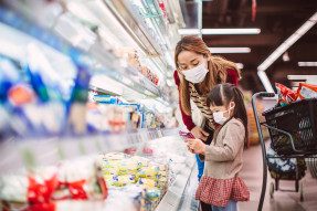 Mother and child wearing masks and grocery shopping
