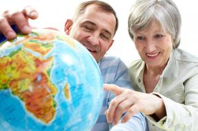 Older man and woman looking at a globe