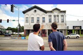 Two men looking at an old building facade
