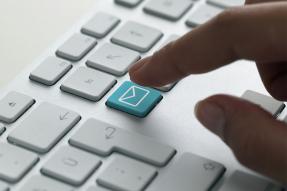 Person about to touch email button on keyboard