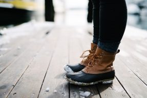 Person wearing snow boots on a deck