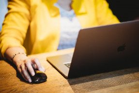 Professional in a yellow jacket working on a computer