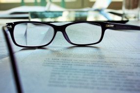 Reading glasses sitting on top of paperwork