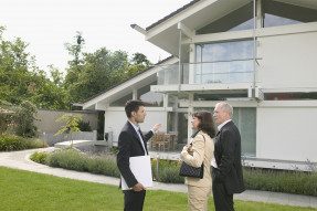 Real estate agent and clients outside home